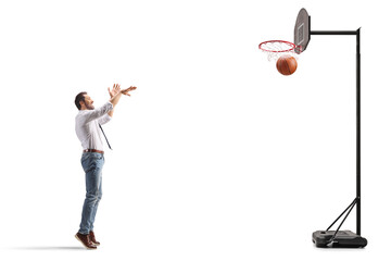 Man in white shirt and jeans shooting a basketball in a hoop © Ljupco Smokovski