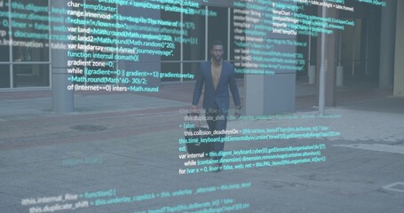 Standing man wearing dark blazer, tan shirt on tiled plaza near glass doors, holographic code