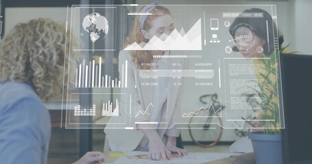 Leaning woman in white blazer reviewing printed plans at office table, with digital overlays