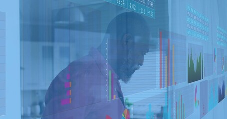 Leaning mature man in business casual shirt studying transparent display at office, colorful charts