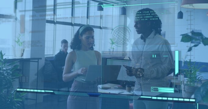 Discussing two coworkers wearing business shirts and holding laptop and tablet in open office, HUD - Powered by Adobe