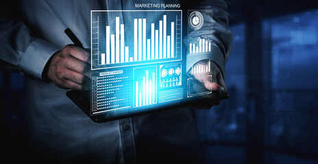 A businessperson engages with marketing analysis using a tablet featuring digital graphs and charts in a modern office setting. The imagery captures insight and innovation in decision-making. Impute