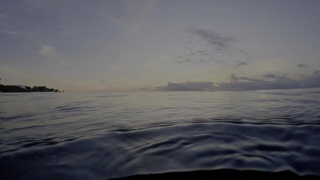 POV of Swimmer in the water watching a peaceful sunset while in the Ocean