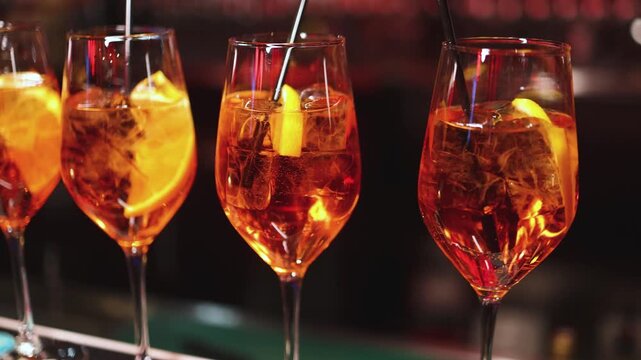 Bartender working, beautiful row line of different coloured liquor alcohol cocktails on a party in a bar, catering banquet on event, barman mixing drinks, selection of beverages in a restaurant club