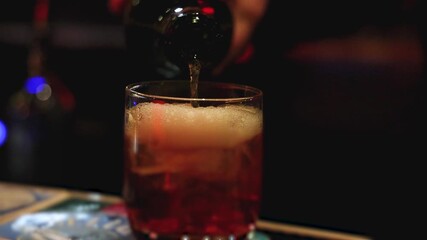 Bartender working, beautiful row line of different coloured liquor alcohol cocktails on a party in a bar, catering banquet on event, barman mixing drinks, selection of beverages in a restaurant club