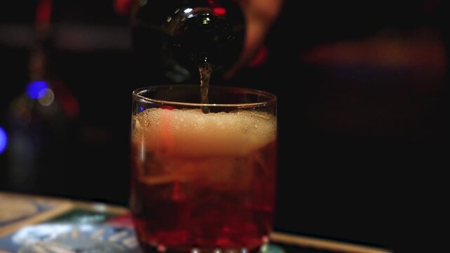 Bartender working, beautiful row line of different coloured liquor alcohol cocktails on a party in a bar, catering banquet on event, barman mixing drinks, selection of beverages in a restaurant club