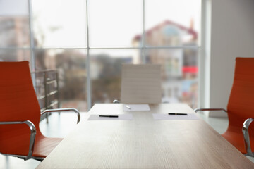 Fototapeta premium Sheets of paper and pens on wooden table in office, closeup