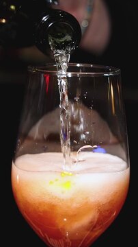 Bartender working, beautiful row line of different coloured liquor alcohol cocktails on a party in a bar, catering banquet on event, barman mixing drinks, selection of beverages in a restaurant club