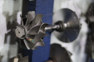 Close up of a metallic turbocharger turbine wheel and shaft assembly, professional mechanical...