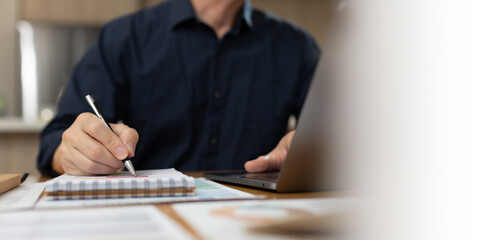 Business professional reviewing and signing financial documents with pen on desk. Corporate...