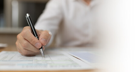 Business professional reviewing and signing financial documents with pen on desk. Corporate paperwork, audit process, accounting review, compliance, administration, and professional business workflow 