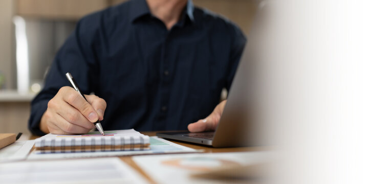 Business professional reviewing and signing financial documents with pen on desk. Corporate paperwork, audit process, accounting review, compliance, administration, and professional business workflow 