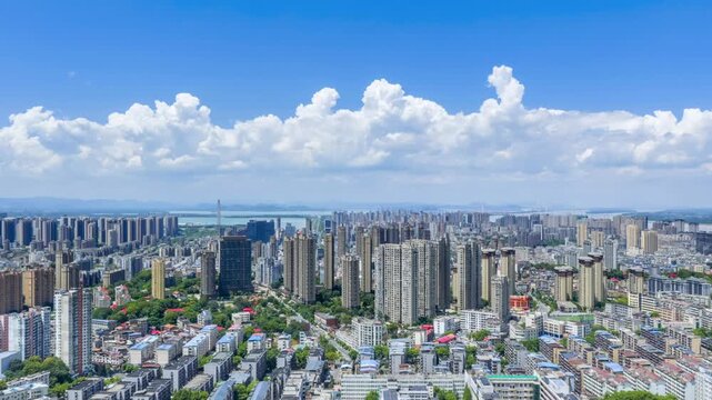 Aerial time-lapse of Jiujiang city under a bright summer sky ,  vivid blue heavens, white clouds, and a livable cityscape in Jiangxi Province, China.