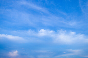 Pale Moon in the Bright Blue Daylight Sky with Soft Clouds,A serene daytime landscape featuring a waxing gibbous moon visible against a clear blue sky.