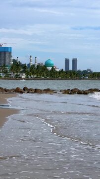 Malaysia, June 31, 2025: The Masjid Bandaraya City Mosque in Kota Kinabalu, Sabah. View of the floating mosque from Likas Bay Beach on the South China Sea. 4K