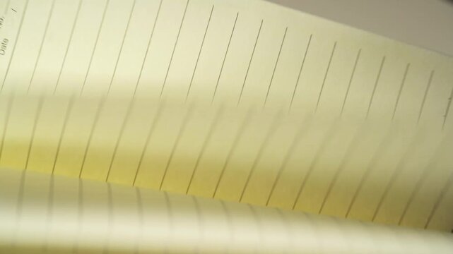 A person is flipping through a notebook
