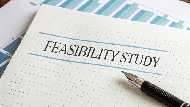 Detailed Document on Feasibility Study with Pen and Graphs in Background for Business Analysis and Planning Purposes