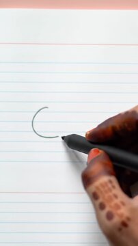 A diverse hand with a sleek matte black stylus draws a perfect small circle on pristine ruled paper with blue lines and pink margin. ECU, soft daylight. Concept of clarity and innovation
