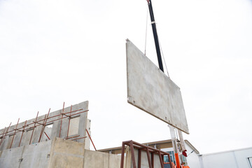 Background banner. Large cranes moving prefabricated walls in factories. Prefabricated concrete walls for building office buildings and residential houses. reinforced concrete wall