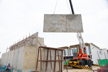 Background banner. Large cranes moving prefabricated walls in factories. Prefabricated concrete walls for building office buildings and residential houses. reinforced concrete wall