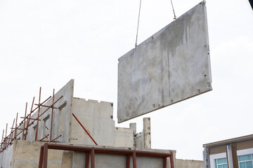 Background banner. Large cranes moving prefabricated walls in factories. Prefabricated concrete walls for building office buildings and residential houses. reinforced concrete wall