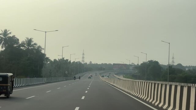 Video footage of a newly constructed highway near Kozhikode, Kerala, India, captured in natural daylight. The smooth road surface, fresh lane markings, and modern infrastructure highlight recent devel