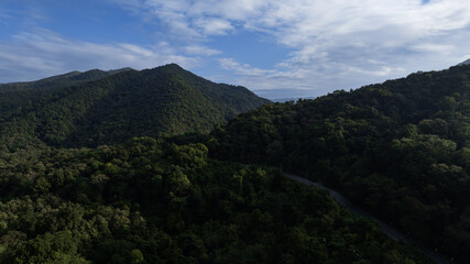 Green mountain scenery with transportation route, ideal for sustainable development and electric vehicle advertising.