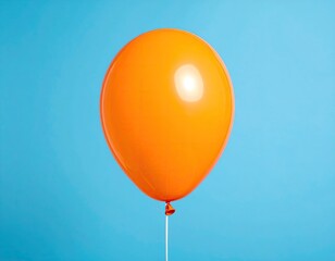 Single orange balloon against a light blue background