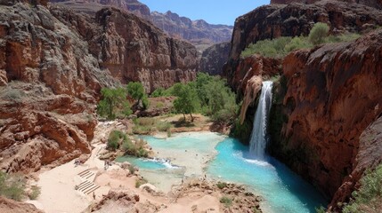 Majestic natural cascade tumbles into turquoise pool surrounded by steep desert canyon walls