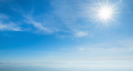 clear blue sky with  bright sun shining through the clouds