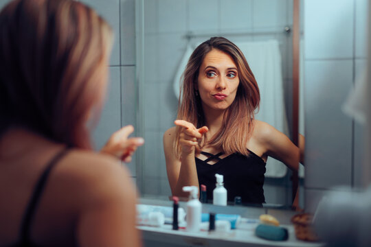Funny Narcissistic Woman Pointing to Herself in the Mirror. Lady giving herself a pep talk for a positive mindset and attitude 
