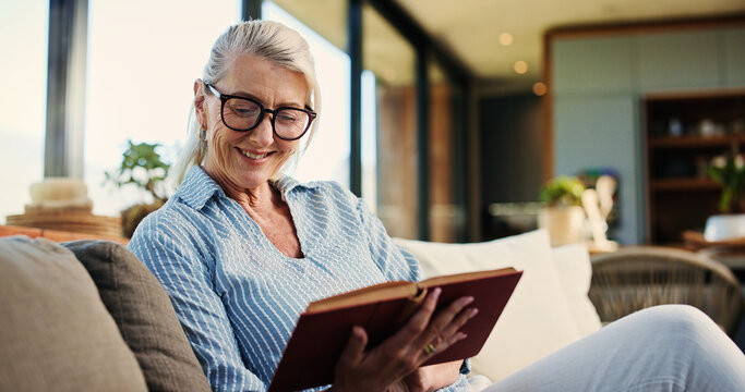 Reading, book and mature woman on sofa with smile, calm and literature hobby on weekend rest. Free time, space and senior person in house with novel, relax and fantasy story on Sunday afternoon.