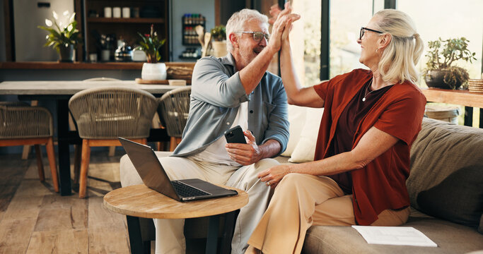 House, high five and old couple with smartphone, laptop and savings with pension fund. Annuity growth, retirement and man on couch, woman and pc with gesture, investment and excited with celebration - Powered by Adobe