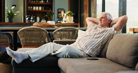 Obraz premium Senior man, relax and thinking on sofa in home with reflection, rest and nostalgia in living room. Elderly person, break and smile with perspective, memory or daydream on couch in retirement at house