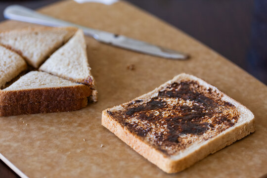 Bread with vegemite being made into sandwich on kitchen bench in Australia