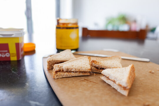 Vegemite sandwich triangles on cutting board on kitchen bench in Australia ready for morning tea