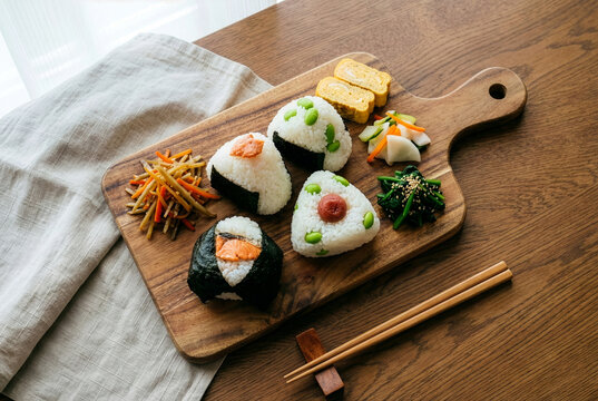 Overhead view of stylish Japanese onigiri rice ball lunch plate on wooden board