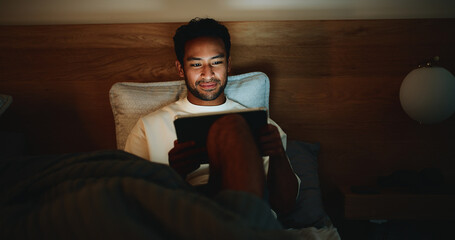 Scroll, night or man in bedroom with tablet, online reading or video search on social media. Smile, dark or male person in house with tech, e book subscription or digital browse in late evening.