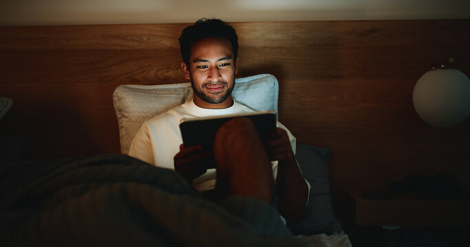 Scroll, night or man in bedroom with tablet, online reading or video search on social media. Smile, dark or male person in house with tech, e book subscription or digital browse in late evening.