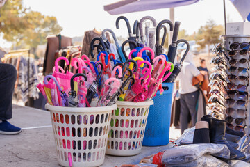 Multicolored umbrellas stacked in a basket at the Chorsu local market in Tashkent, Uzbekistan.