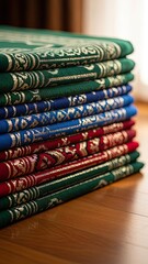 Vibrant stack of intricately patterned cultural textile mats in deep green, blue, and red hues, displaying rich traditional designs, ideal for decorative or spiritual use