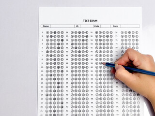 Student hand holding pencil filling out multiple choice answer sheet.1