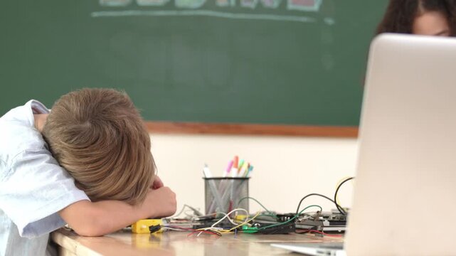 Diverse smart student working together to fix main board at stem class while looking at laptop screen at blackboard. Group of skilled children learning and studying about electronic machine. Pedagogy. - Powered by Adobe