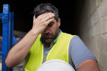 Stressed Construction Worker Holding Head in Frustration