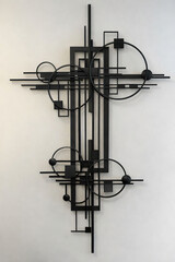 Abstract black metal wall art sculpture on white wall