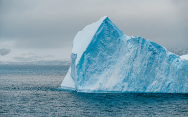 Massive Iceberg in Antarctica Side. Close Up View of Huge Piece of Ice Floating on Ocean. White and...