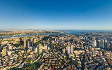 Istanbul, Turkey. Panoramic aerial drone view of European part city skyline with modern skyscrapers and Bosphorus Strait at sunset, clear sky. Aerial view