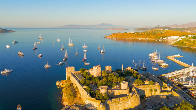 Bodrum, Turkey. Aerial drone view of Bodrum Castle guarding harbor entrance with yachts sailing in Gokova Bay during morning light.. Aerial View