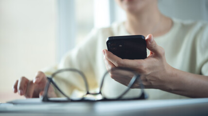 Closeup, woman using smartphone and laptop computer for online shopping, digital banking, social network via mobile app. 