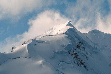 Close Up Beautiful Mountain Peak in Antarctica Covered in Snow Fresh Powder Christmas Ice Glacier. Blue Sky with Swirling Clouds. Frozen Landscape. © And They Travel